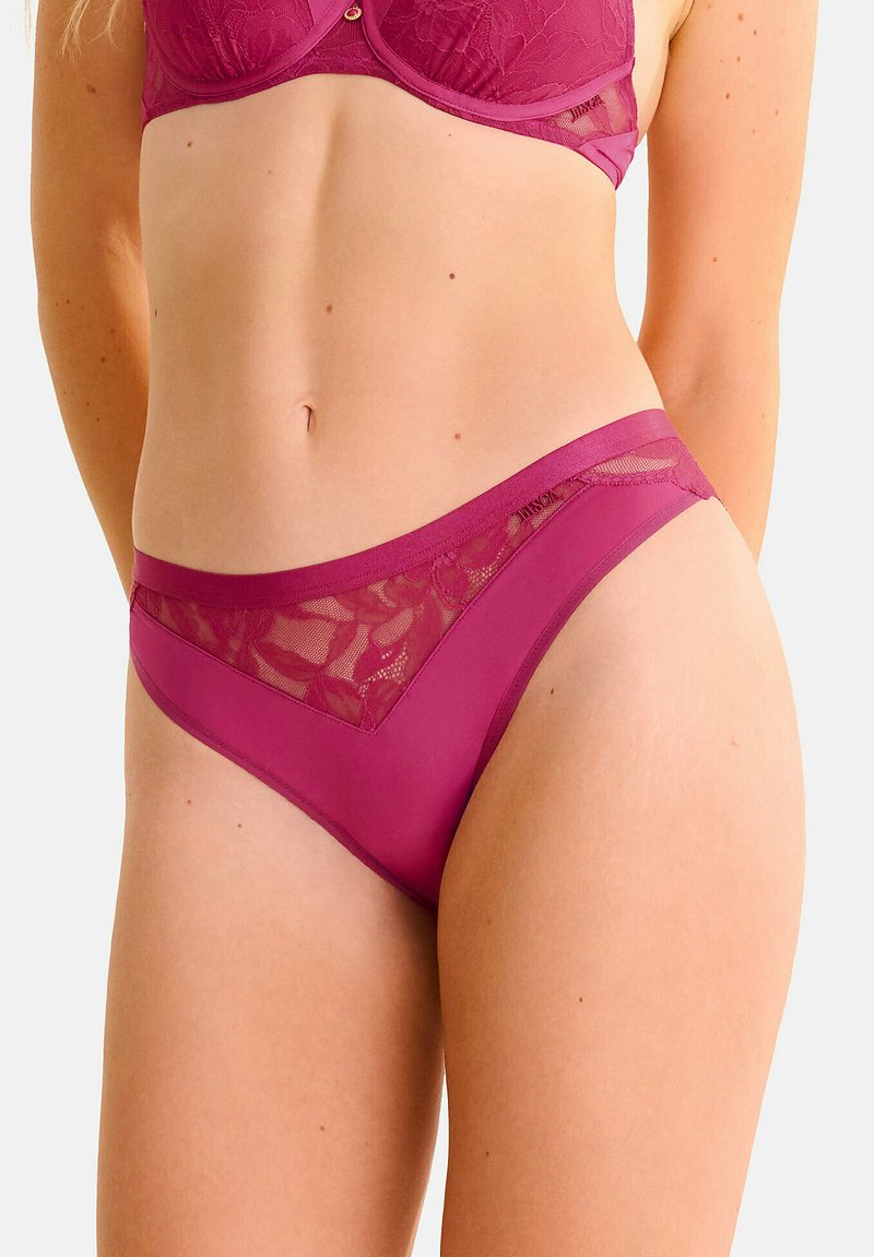 Culottes en dentelle magenta et panneaux transparents présentant une taille lisse et des détails en dentelle florale pour une combinaison de textures et de couleurs.