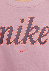 Sudadera rosa con gran texto bordado en gris oscuro que dice "nike" con acentos en naranja. Tejido texturizado con cuello redondo.