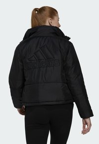 Zwarte pufferjack met hoge kraag, geperst Adidas-logo op de rug, geborduurd ontwerp en elastische manchetten voor een snug fit.