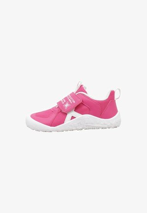 Chaussure de sport rose pour enfants avec semelle blanche, bride auto-agrippante et languettes sur la languette et le talon.