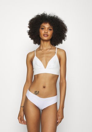 White cotton bralette with a deep V-neck and thin straps, paired with matching low-rise briefs. Smooth texture and minimalist design.