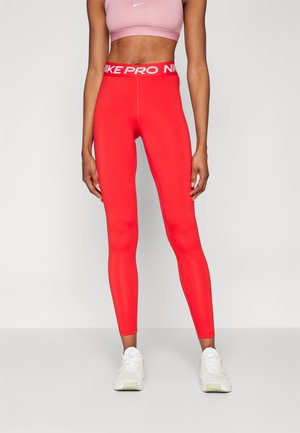 Leggings deportivos rojos con una cintura alta que presentan el texto blanco "NIKE PRO". Fabricados con un material elástico, se ajustan al cuerpo y ofrecen una textura suave.