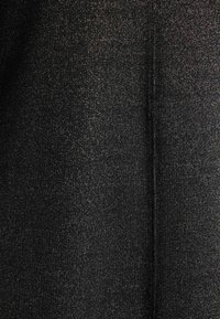 Czarna tkanina o teksturowanej, prążkowanej powierzchni i subtelnych, błyszczących akcentach, tworząca migoczący efekt w całej tkaninie.