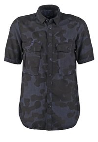 Koszula z krótkim rękawem, zapinana na guziki, z wzorem kamuflażu w ciemnoszare i czarne kolory oraz dwoma kieszeniami na piersi zapinanymi na guziki.