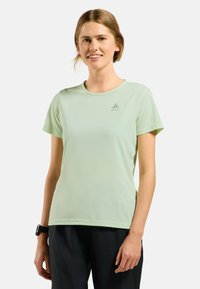Light green, short-sleeve performance t-shirt with a smooth texture and a fitted design. Features small brand logo on the chest.