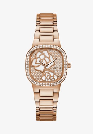 Roosa kuldne kell ruudukujulise korpusega, millel on lillekujundus ja kristallidega kaetud äär. Metallist link-rihm täiendab peent ilmet.