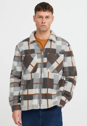 Fleecejack met een grijs-wit ruitpatroon en oranje accenten, twee borstzakken en een rits aan de voorkant. Geweven stof.