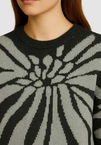 Maglione a maglia con scollatura rotonda, nelle tonalità di grigio e nero, con un motivo a raggi contrastante su tutta la superficie.