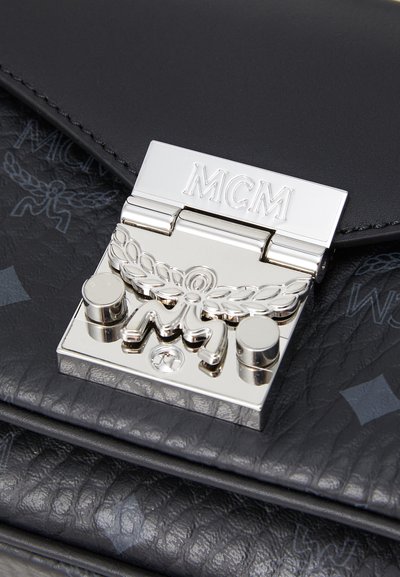 Borsa in pelle nera con chiusura in argento e logo inciso con ghirlanda decorativa. Superficie testurizzata con sottili dettagli a motivi.