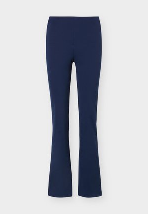 Pantalon ajusté bleu marine avec une légère évasure en bas, présenté sur un fond clair uni.
