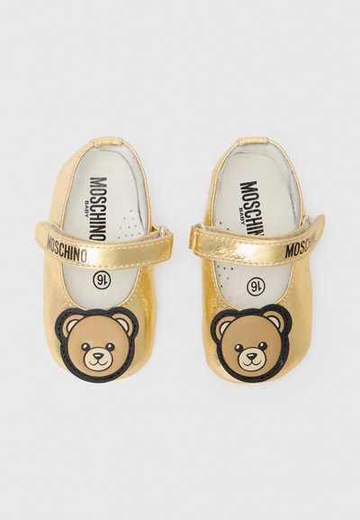 Zapatos de bebé de piel dorada con un diseño de cara de oso redonda en la puntera, con una correa para un ajuste seguro y un interior acolchado.