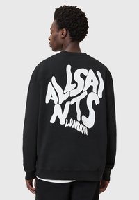 Schwarzer Kapuzenpullover mit einem großen weißen Grafikdesign auf der Rückseite, das verzerrt den Text "ALLSAINTS LONDON" zeigt. Der Stoff hat eine strukturierte Oberfläche.