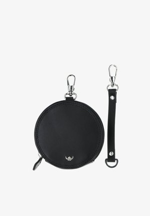 Porte-monnaie rond en cuir noir avec fermeture éclair et fermoir argenté, accompagné d'une bandoulière en cuir noire détachable avec des accessoires argentés.