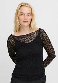 Schwarzes Spitzenoberteil mit langen Ärmeln, einem Rundhalsausschnitt, strukturiertem Blumenmuster und halbtransparentem Stoff. Enganliegendes Design mit abgerundetem Saum.