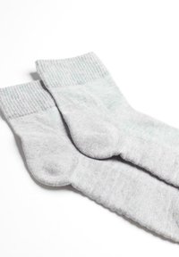 Calzini di cotone grigi con orli a coste, caratterizzati da una texture liscia e un design classico. Il tessuto appare morbido e durevole.