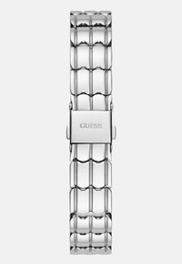 Edelstahl-Uhrenarmband mit glänzender Oberfläche, ausgestattet mit ineinandergreifenden Gliedern in rechteckiger Form. Mit eingraviertem "GUESS"-Logo auf der Schließe.