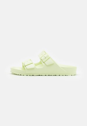 Sandales moulées vert clair avec deux boucles ajustables, semelle texturée et semelle rainurée pour une meilleure adhérence, présentant un design ouvert.