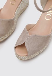 Sandalias de cuña de ante beige con la puntera abierta, que cuentan con un diseño cruzado y detalles de talón de yute trenzado. Forro interior suave.