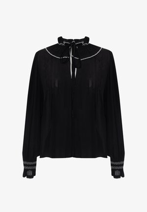 Blusa negra con un alto cuello con volantes, lazo en el frente y mangas largas. Presenta bordados blancos en el cuello y los puños. Tela transparente.