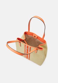 Sac fourre-tout en tissu tissé beige avec des bordures en simili-cuir orange. Il possède deux rayures orange, une ouverture en haut et des poignées courtes.