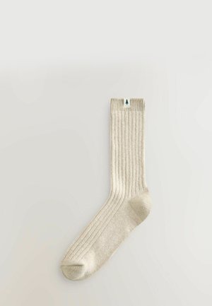 Kermankotoinen ribbiskoska, jossa on pehmeä rakenne ja vihreä puulogokyltti ylhäällä. Standardsukkamuoto, jossa on vahvistettu varvas.