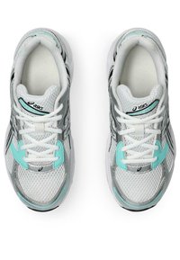 Baskets de sport grises et blanches avec une tige en maille, des accents turquoise et des lacets blancs. Design avec bout rond et semelle rembourrée.