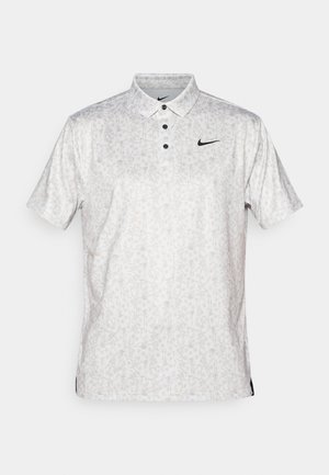 Vit polo-shirt med ett subtilt blommönster, svarta knappar och en svart Nike-logga på bröstet. Kortärmad, klassisk krage och sprund på sidorna.