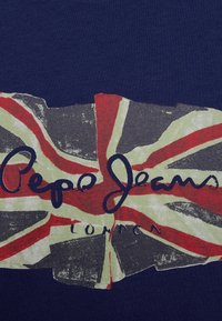 Granatowy t-shirt z grafiką w stylu vintage przedstawiającą Union Jack w kolorach czerwonym, białym i zielonym, z napisem "Pepe Jeans London".