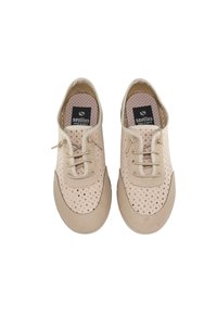 Zapatos casuales beige perforados con cordones, punteras redondeadas, suelas de goma claras y etiquetas "sevillas made in Spain" en el interior.