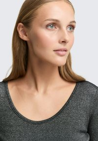 Błyszcząca, dopasowana czarna bluzka z dekoltem w serek, charakteryzująca się teksturowanym materiałem i subtelnymi błyskotkami. Krótkie rękawy widoczne przy ramionach.