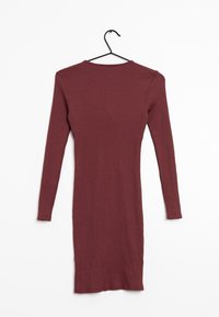 Geribbelde jurk van volledige lengte in bordeauxrood. Lange mouwen en ronde hals. Glad textuur met een aansluitende pasvorm. Hangt aan een zwarte hanger.
