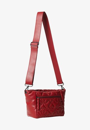 Bolso cruzado de piel roja con textura acolchada, que cuenta con un bolsillo frontal con cremallera y una correa para el hombro ajustable. Presenta patrones florales decorativos estampados.