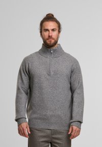 Grey knitted sweater with a high collar and half zip. Features ribbed cuffs and hem. Soft texture, relaxed fit with minimalistic design.