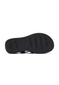 Suola in gomma nera, design piatto con grip testurizzato e quattro scanalature prominenti per trazione e flessibilità. Finitura pulita e opaca.