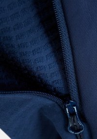 Navy ritsjack detail met een gladde buitenkant en een gestructureerde voering. Voorzien van een stevige rits met bijpassende trekknop.