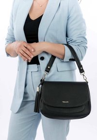 Czarna skórzana torba na ramię o fakturowanym wykończeniu, zamknięcie na magnes, oraz ramiączko z ozdobnym chwostem.