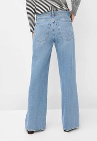 Light blue wide-leg jeans made of denim, featuring a high waist, five pockets, and subtle stitching details.