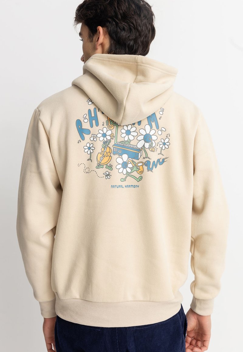Sudadera beige con capucha ajustable que presenta coloridos gráficos florales y musicales en la parte posterior. Tela suave, corte holgado y puños acanalados.