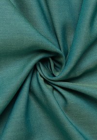 Tessuto testurizzato di colore verde petrolio, caratterizzato da un motivo intrecciato con fini punti, attorcigliato in una forma a spirale, che mette in mostra la sua flessibilità e lucentezza.