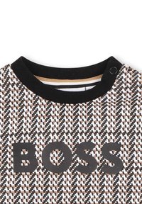 Felpa a maniche lunghe in bianco e nero con motivo, caratterizzata da un collo rotondo a coste nere e audace scritta "BOSS" in nero sul davanti.