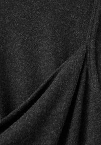 Černá látka s měkkou, načechranou texturou; záhyby a vrstvy s jemnými odstíny a hloubkou.