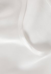 Tessuto di raso bianco con una consistenza liscia, caratterizzato da una leggera lucentezza e un collo rotondo. Il materiale si stende piatto, mostrando la sua finitura morbida.