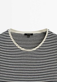 Maglione a righe bianche e nere con scollo arrotondato, caratterizzato da un bordo chiaro intorno al colletto. Tessuto morbido e design informale.