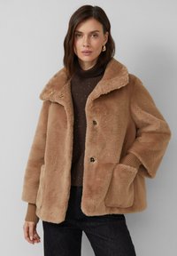 Veste en fausse fourrure marron avec un large col, deux poches avant, des boutons en ton or et des poignets en maille côtelée. Présente une finition douce et texturée.
