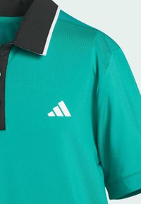 Turkiser polo shirt med sort krave, hvide accenter og et adidas-logo. Lavet af glat, åndbart stof, med en knaplukning.