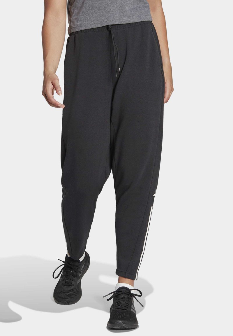 Pantalones jogger negros con un ajuste relajado, cinturilla elástica, bolsillos laterales y acentos de rayas blancas a lo largo de las costuras. Tela suave y casual.