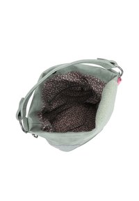 Lichtgroene schoudertas met een gepatterneerde bruine stofvoering, binnenzak met rits en een verstelbare strap met metalen ringen.