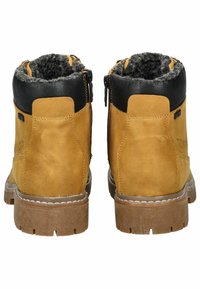 Bottines en daim marron avec des accents en cuir noir, doublure en fausse fourrure, fermeture éclair sur le côté et semelle en caoutchouc robuste.