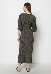 Robe maxi à motifs noir et crème avec des manches amples, taille cintrée et ourlet droit. Tissu lisse et design à longueur de cheville.