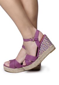 Sandali wedge in tessuto viola con cinturini incrociati, piattaforma avvolta in juta e dettagli intrecciati colorati sul tacco wedge.